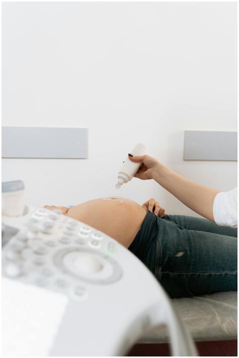 A pregnant woman receives an ultrasound exam in a
