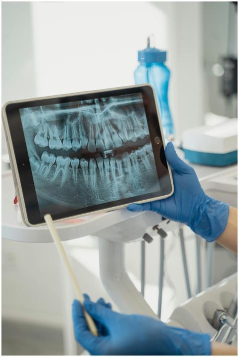Dentist displaying dental x-ray on tablet in a mod