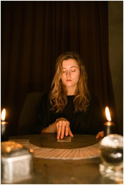 Caucasian woman practicing tarot reading with cand