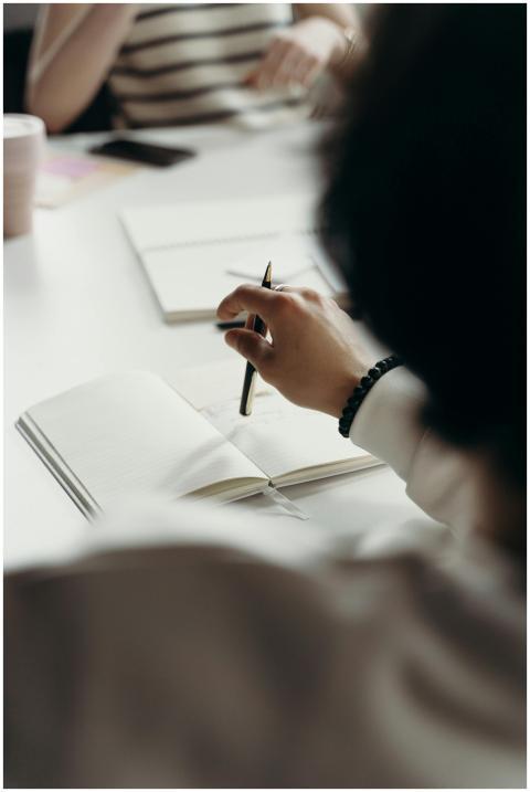 Close-up of professionals brainstorming with noteb