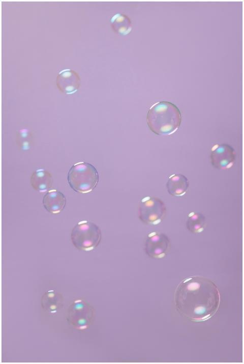Floating soap bubbles against a serene lilac backg