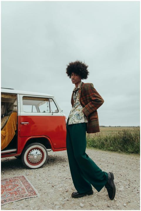 Stylish young man with afro standing by a vintage