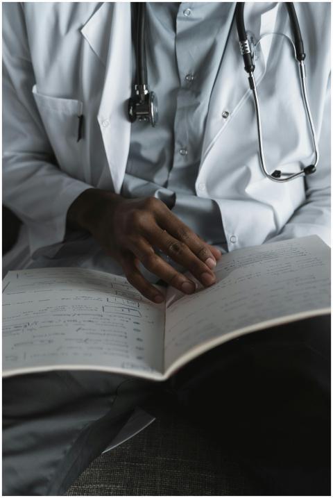 Close-up of a doctor reading medical notes, wearin