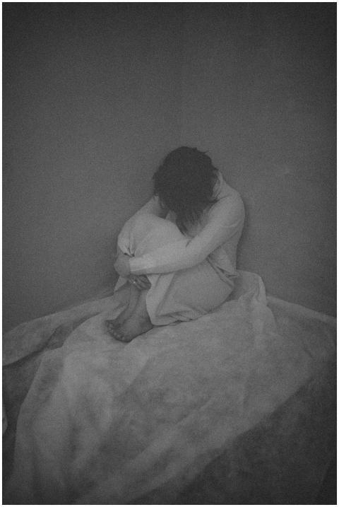 A black and white image capturing a woman sitting