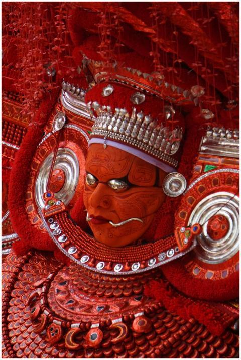 Detailed close-up of a Theyyam performer's vibrant