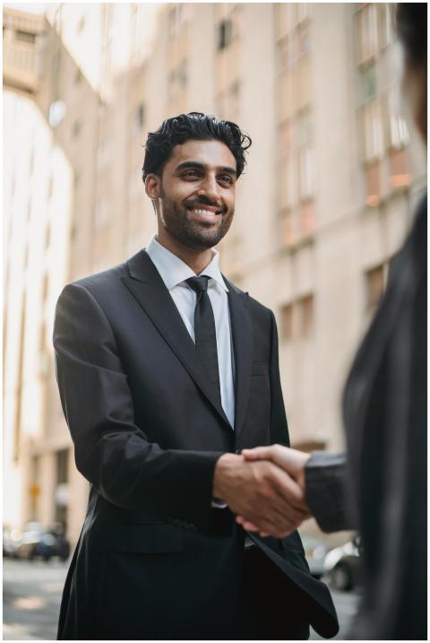 Confident businessman in black suit smiling while