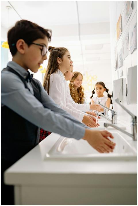 A group of children washing hands at a sink, promo
