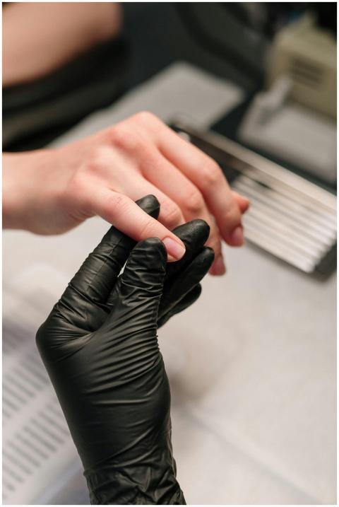 A professional manicurist wearing black gloves pro