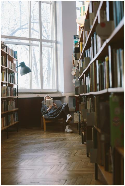 Woman reading a book in a peaceful library filled