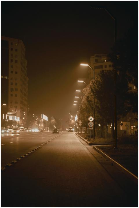 A serene, empty street illuminated at night in Tir