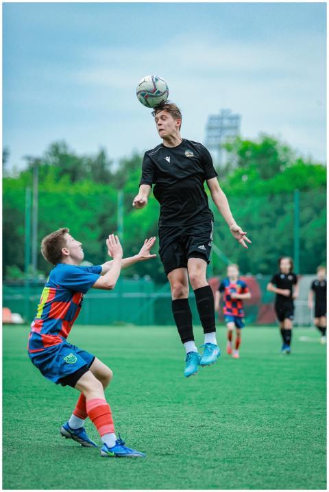 Two male soccer players compete intensely on a gre
