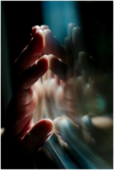 A hand pressing against a glass surface with vivid