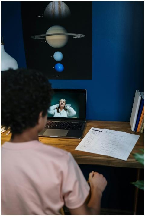 A child engaging in online learning at home with l