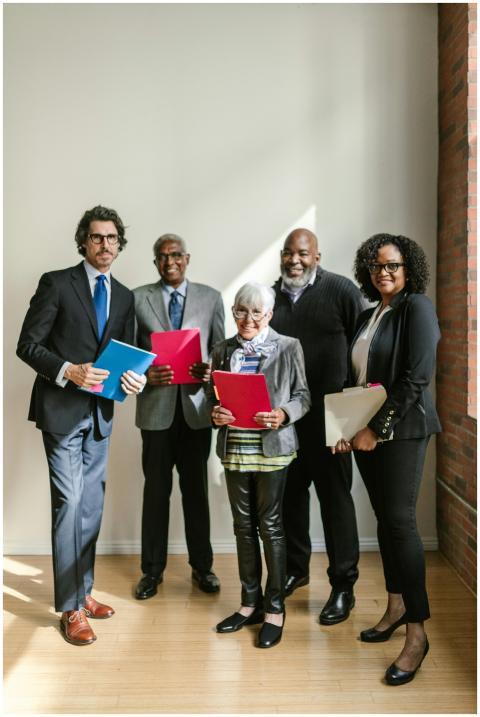 A diverse group of professionals holding folders a