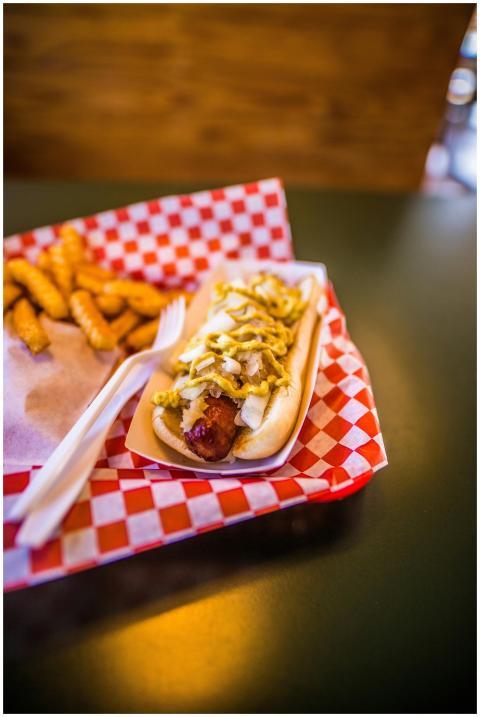 Delicious hotdog topped with mustard and onions, s