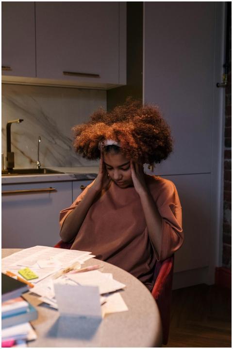 A young woman with afro hair looks exhausted while