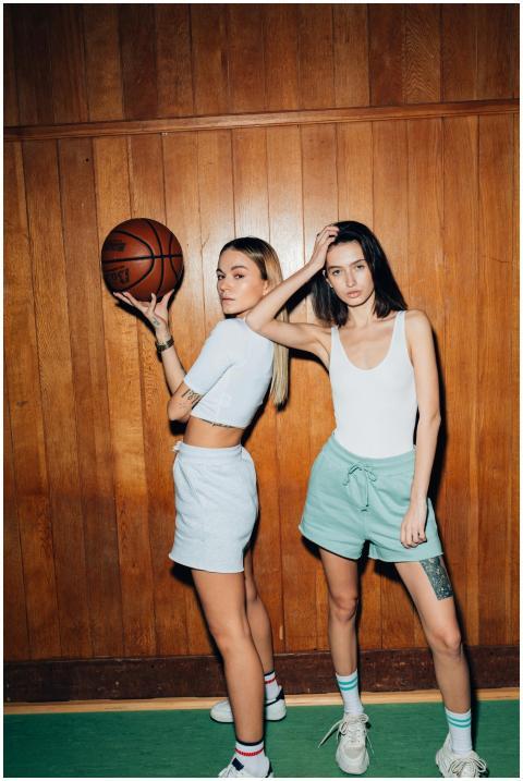 Two young women in athletic wear pose stylishly in