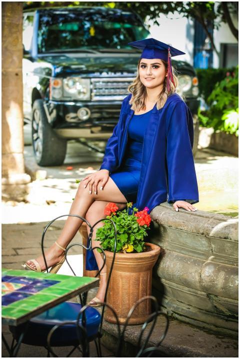 Young woman in graduation attire celebrating outdo