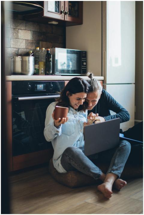 Smiling couple bonding over coffee and laptop in a