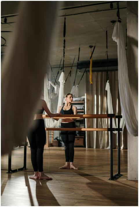 A young woman practices yoga in a modern studio, e