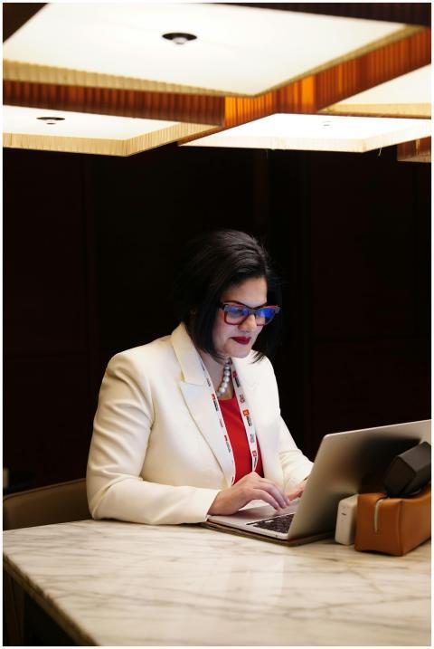 Elegant businesswoman in white suit working on a l