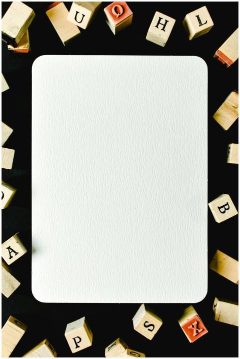 A blank white card surrounded by wooden alphabet b