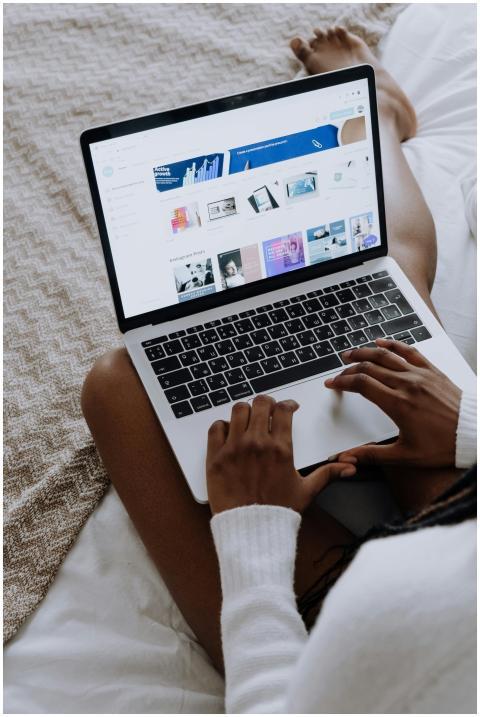 A woman browsing digital designs on a laptop while
