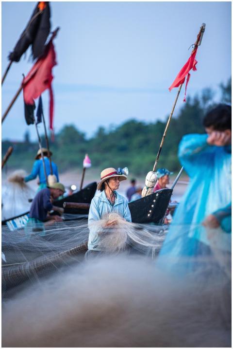 Fishermen working with nets on traditional boats n