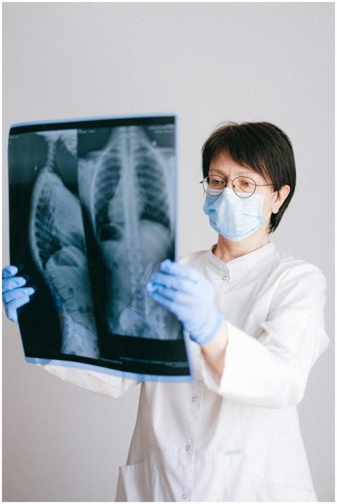Medical professional in PPE examining chest X-ray