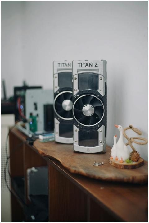 Dual graphics cards displayed on a wooden shelf in