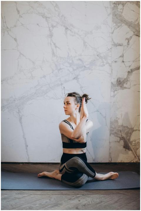 A woman stretching in a yoga pose indoors with a m