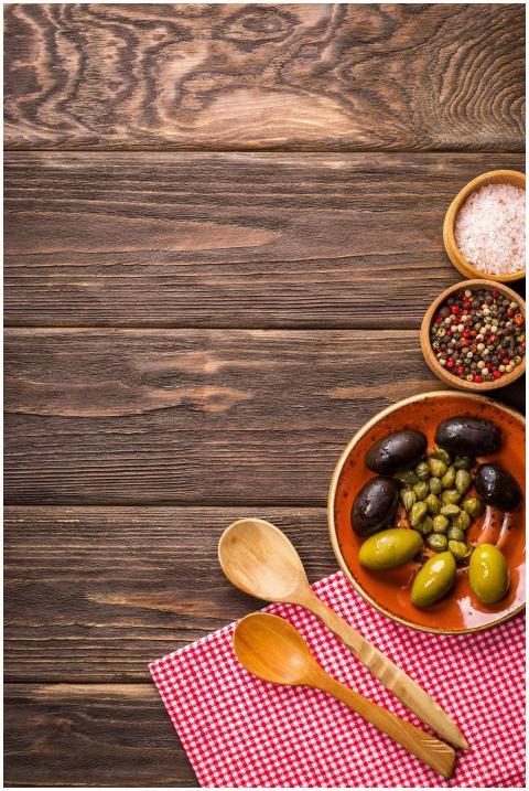 A rustic kitchen scene featuring olives and spices