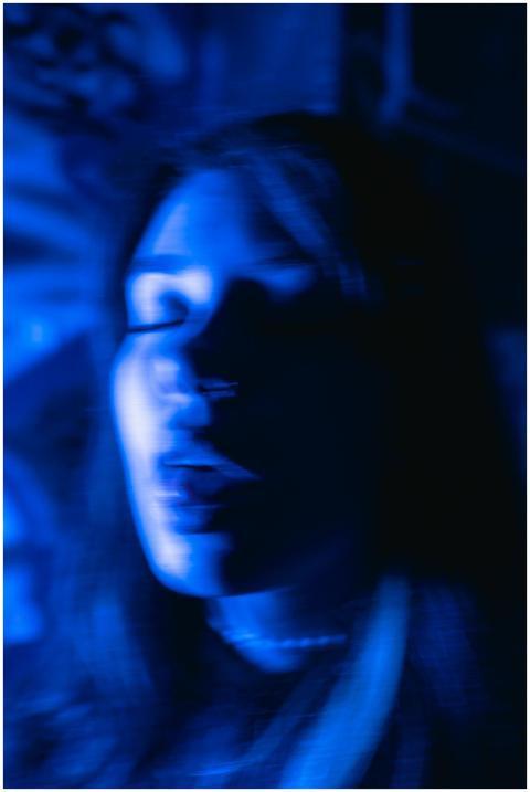 Blurry long exposure portrait of a woman in blue l