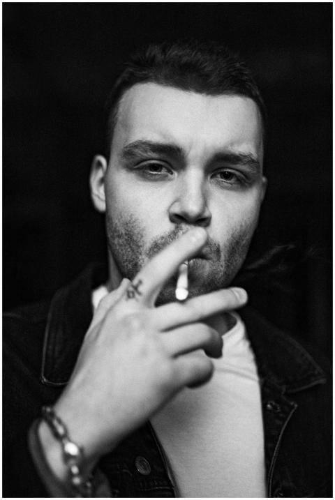 Monochrome portrait of a young man smoking a cigar