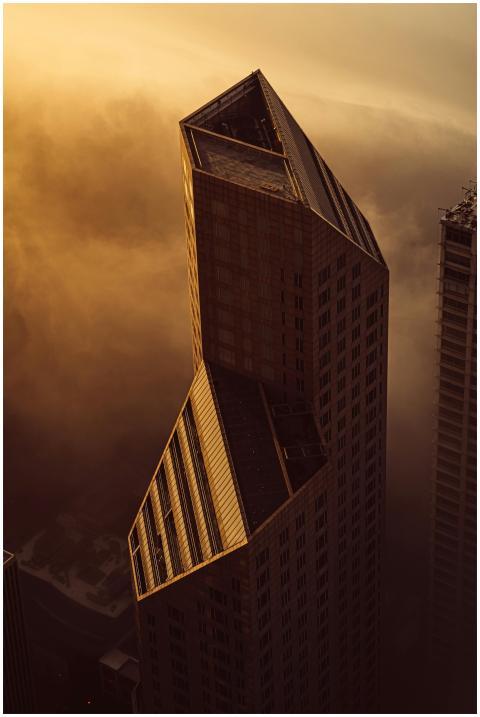 A futuristic skyscraper emerges eerily through den