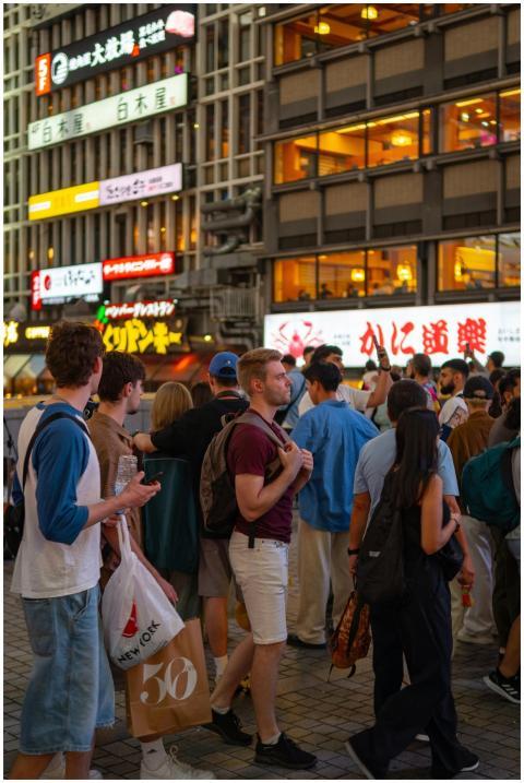 Crowd of people standing on a city street at night