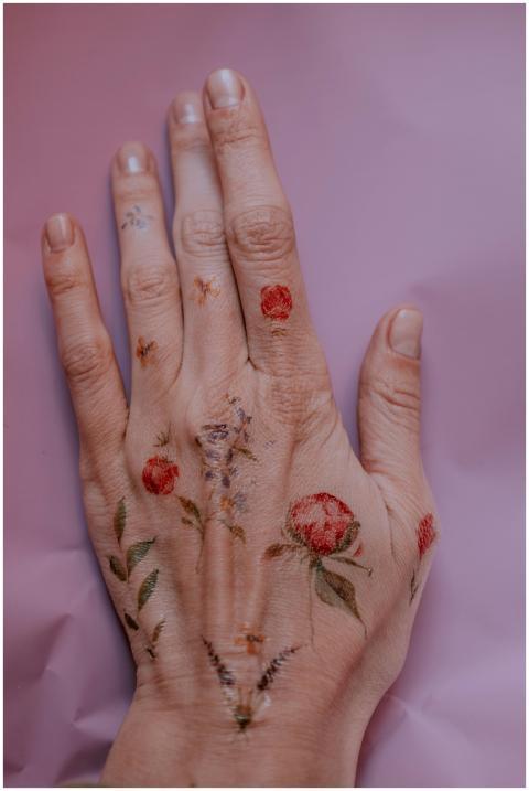 Close-up of a hand adorned with delicate floral te