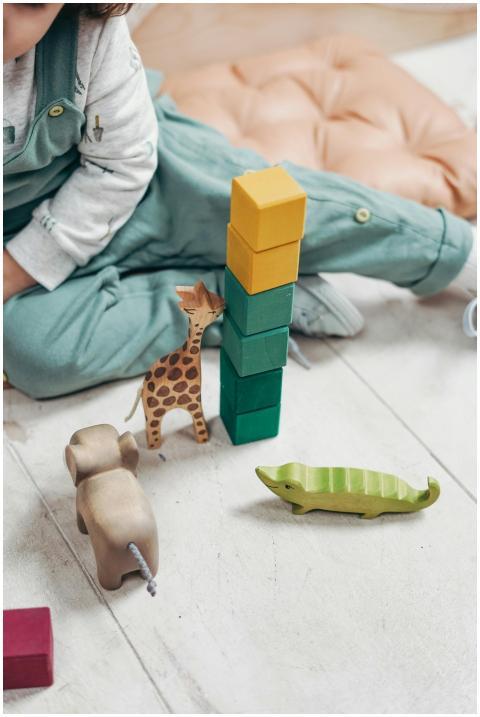 A child plays with colorful wooden toys and blocks