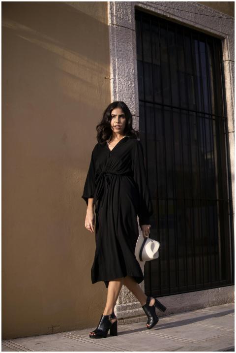 Elegant woman in a black dress walking on a Mérida