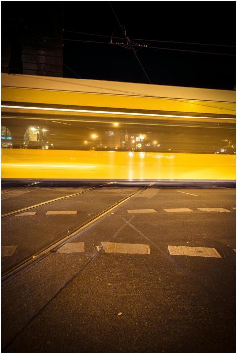 Blurred yellow tram on a Berlin street at night, c