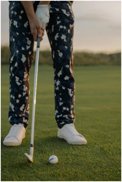A golfer poised to hit a ball on a sunny golf cour