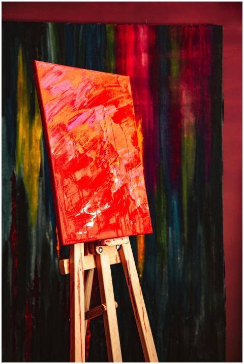 A colorful abstract painting displayed on a wooden