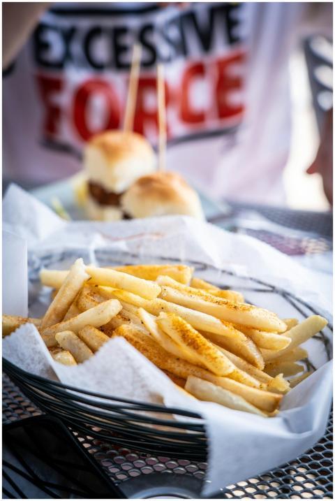 Tasty French fries with seasoning, served alongsid