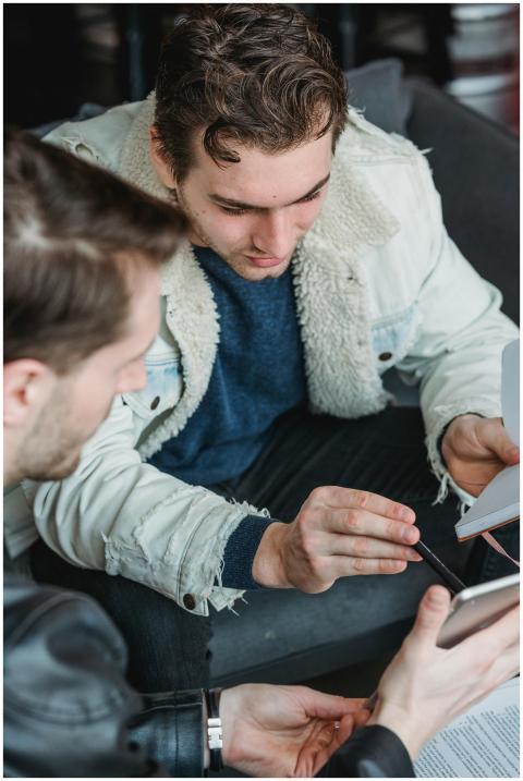 High angle of crop man showing tablet to partner s