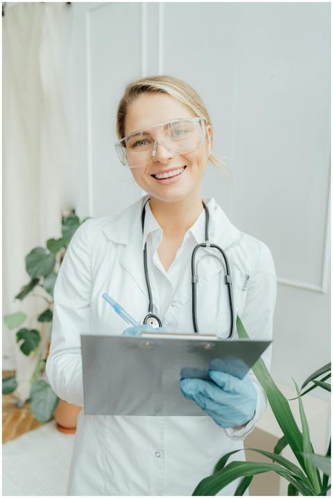 Confident female doctor with clipboard in a bright