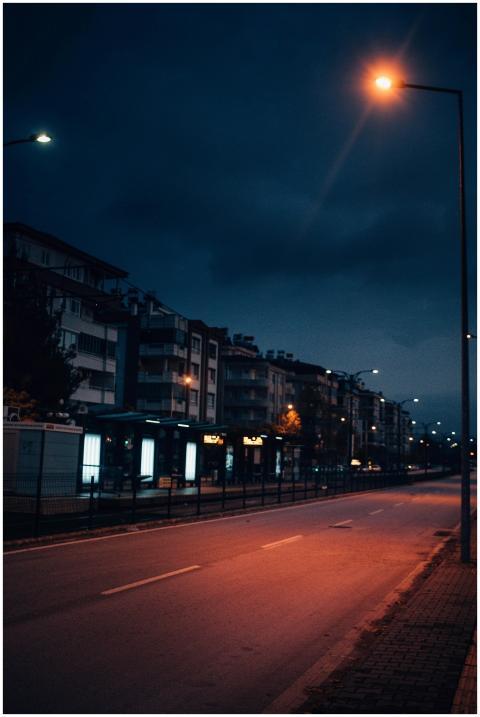 Deserted city street at night with rows of illumin