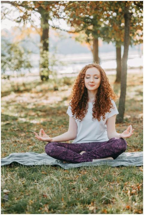 Woman meditating in a serene park during springtim