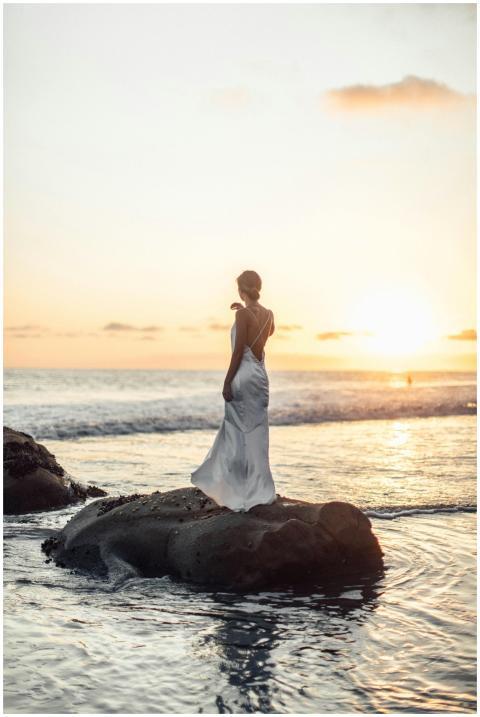 Elegant woman in a flowing dress stands on Malibu