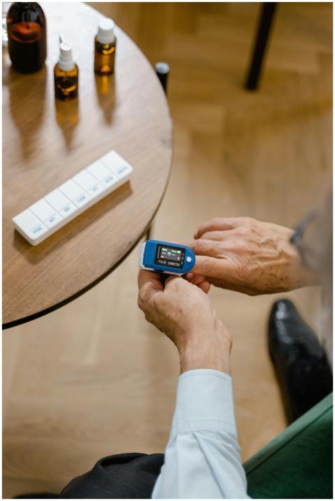 An elderly individual checks blood oxygen using a