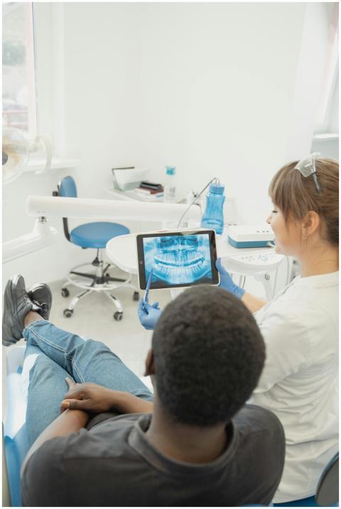 Dentist showing patient a dental x-ray on a tablet